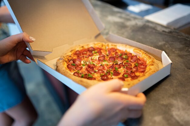 Manos de alto ángulo sosteniendo pizza