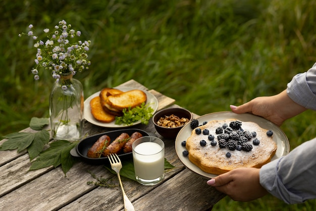 Foto gratuita manos de alto ángulo sosteniendo plato con pastel