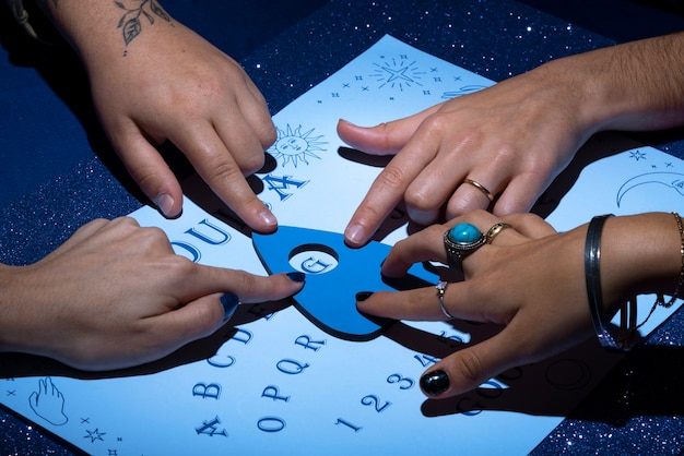 Manos de ángulo alto usando tablero de ouija