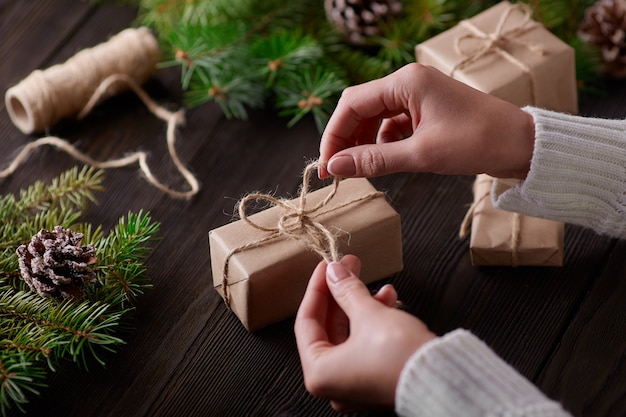 Foto gratuita manos atando el nudo de cordel de paquetes de regalo