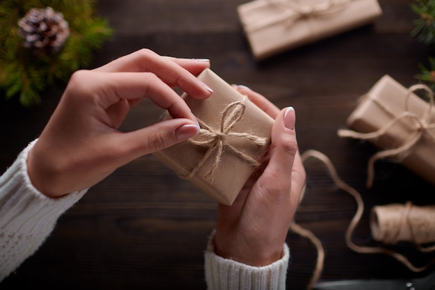 Foto gratuita manos atando el nudo de cordel de paquetes de regalo