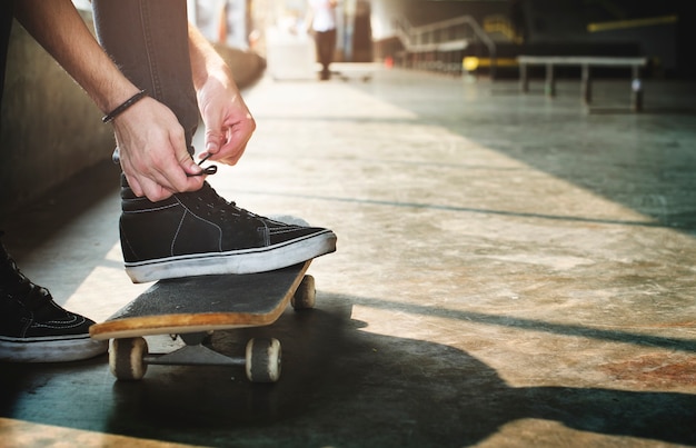 Manos atando zapatos túnicas en patineta