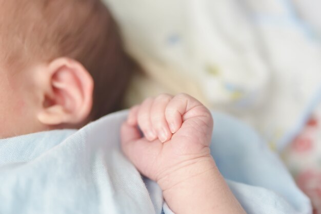 Manos del bebé. El niño chupa los puños