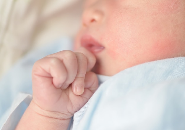 Manos del bebé. El niño chupa los puños