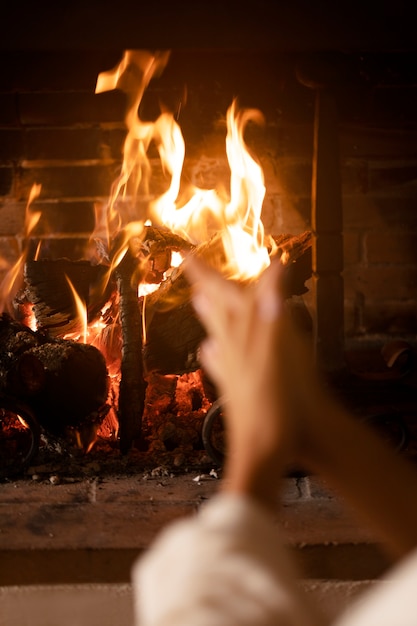 Manos calentándose junto al fuego de cerca