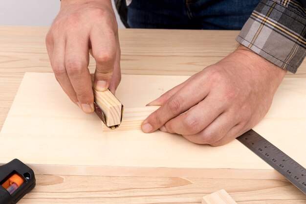 Manos de carpintero experto trabajando con trozos de madera