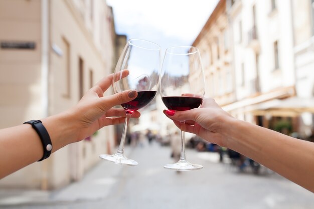 Manos cerca de la pareja brindando copas de vino