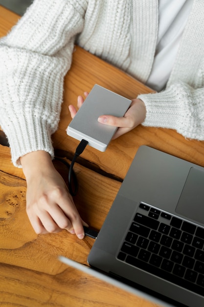 Manos conectando ssd a la computadora portátil en el escritorio