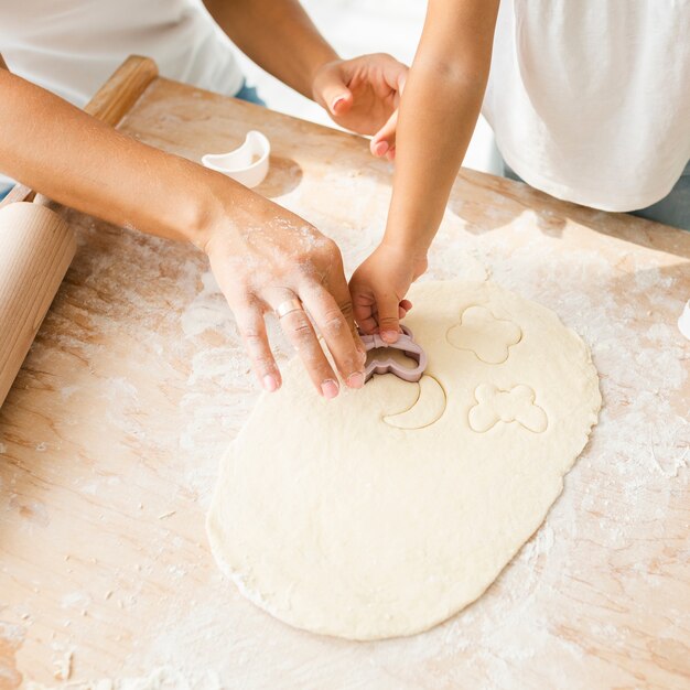 Manos cortando masa para galletas