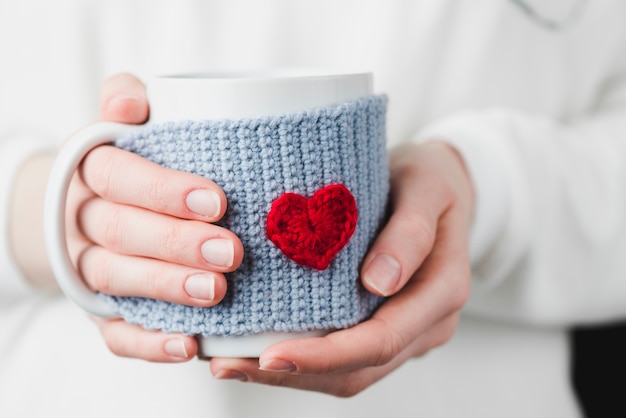 Manos de la cosecha con la taza bonita