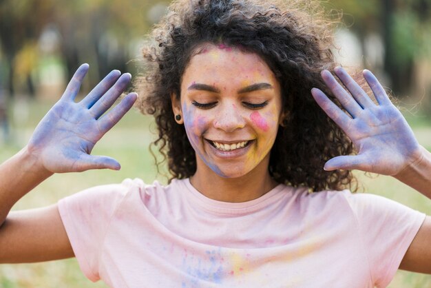 Manos cubiertas de pintura azul pose de mujer en holi