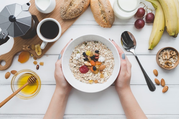 Manos de cultivo sosteniendo el tazón con muesli