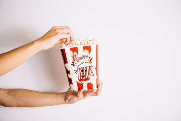 Manos de cultivo tomando palomitas de maíz