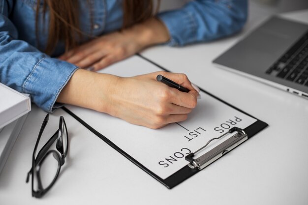 Manos escribiendo en papel en el escritorio