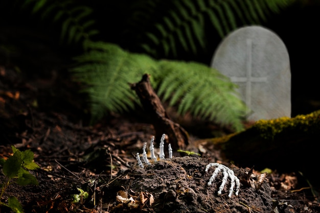 Manos esqueléticas en el suelo en un cementerio