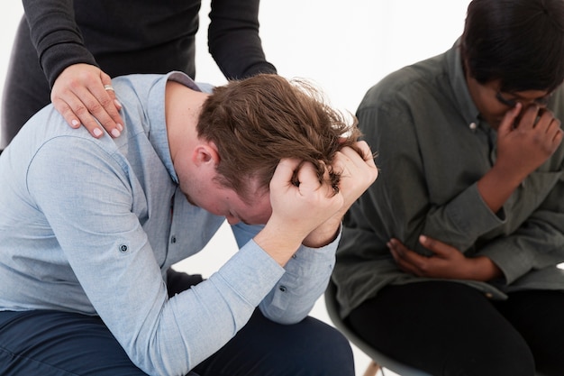 Manos femeninas consolando paciente masculino triste