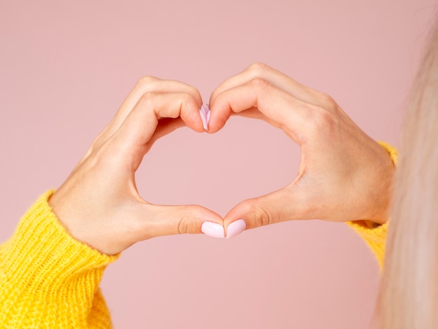 Manos femeninas gesticulando corazón