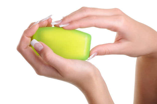 manos femeninas humanas sosteniendo el jabón verde