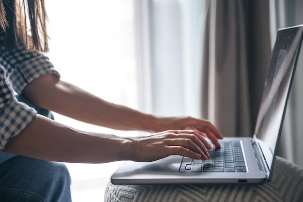 Las manos femeninas del primer están trabajando en una computadora portátil