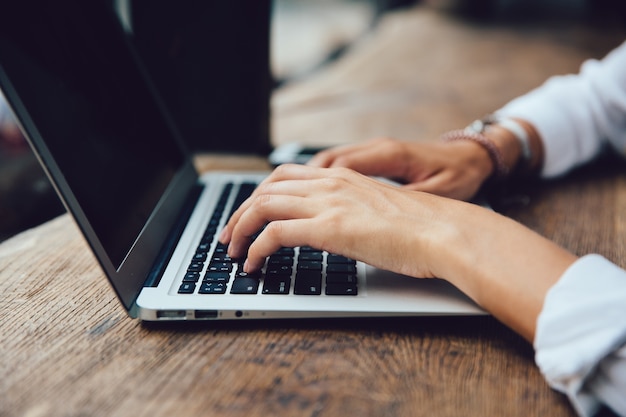 Manos femeninas que pulsan en el teclado del netbook, opinión del primer. Concepto de negocio.