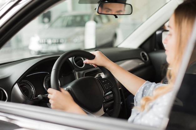 Manos femeninas que sostienen una rueda de coche moderno