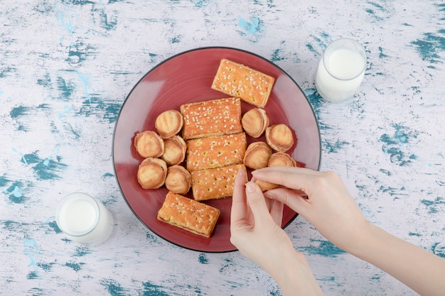 Manos femeninas sosteniendo nueces de mantequilla con leche condensada.