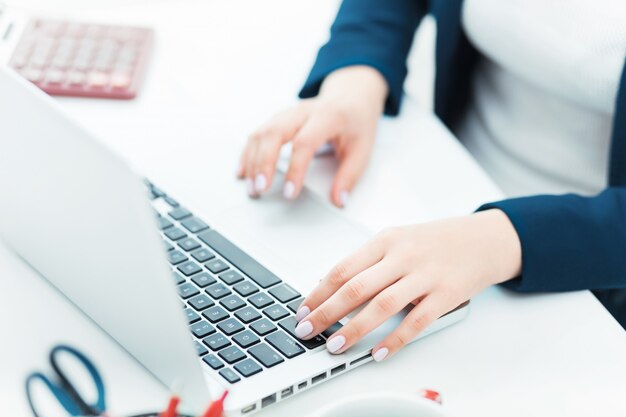 manos femeninas en el teclado de su computadora portátil