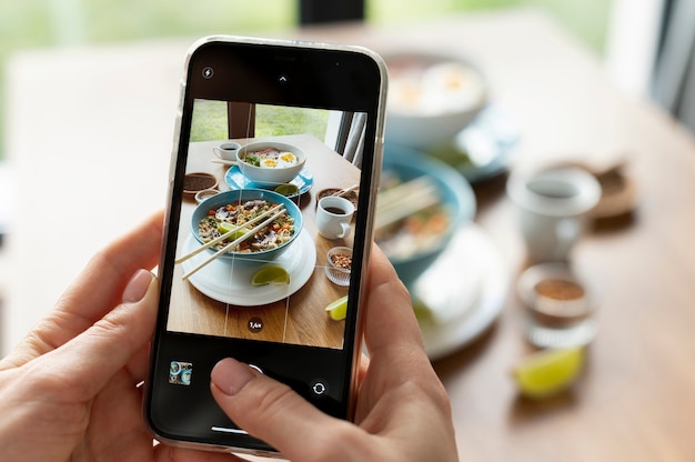 Foto gratuita manos femeninas tomando fotos de dos tazones de ramen