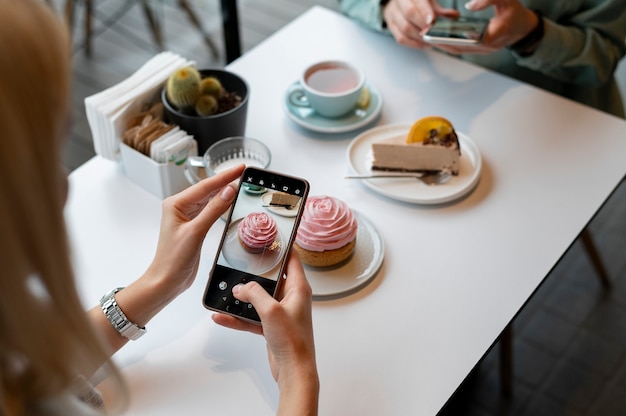 Manos femeninas tomando fotos de un muffin