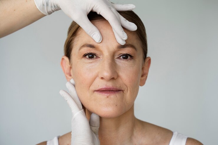 Foto gratuito manos con guantes sosteniendo la vista frontal de la cara de la mujer