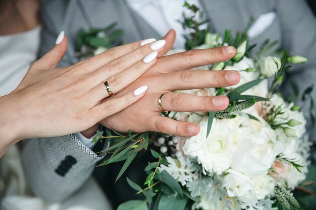 Manos de un guapo esposo y esposa el día de su boda.