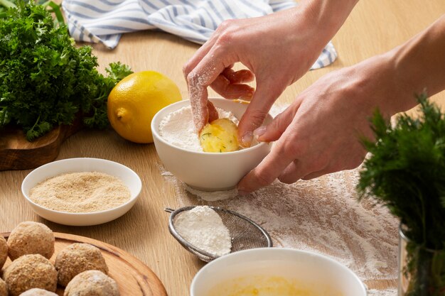 Manos haciendo croquetas de comida de cerca