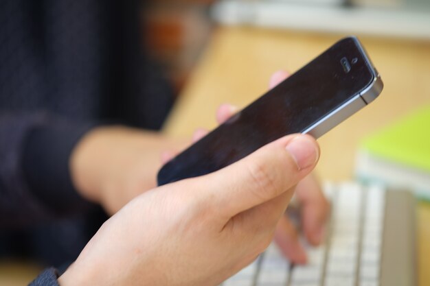 Manos de hombre asiático usando teléfono inteligente, concepto de medios de comunicación social