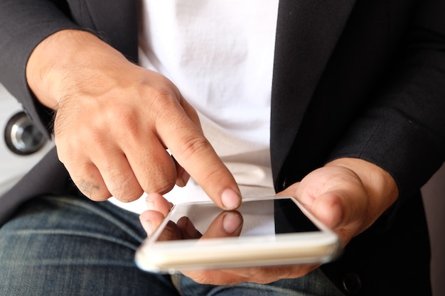 Manos de hombre asiático usando teléfono inteligente, concepto de medios de comunicación social