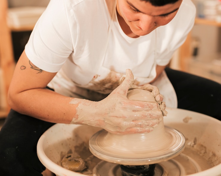 Foto gratuito manos del hombre haciendo olla de cerámica en la rueda de alfarería