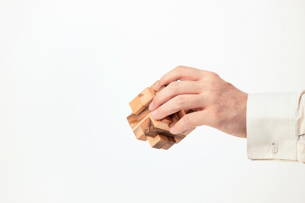 Las manos del hombre con rompecabezas de madera.