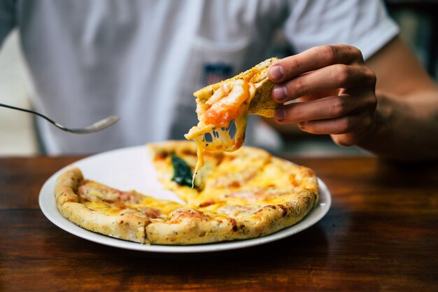 las manos del hombre sostienen la pizza