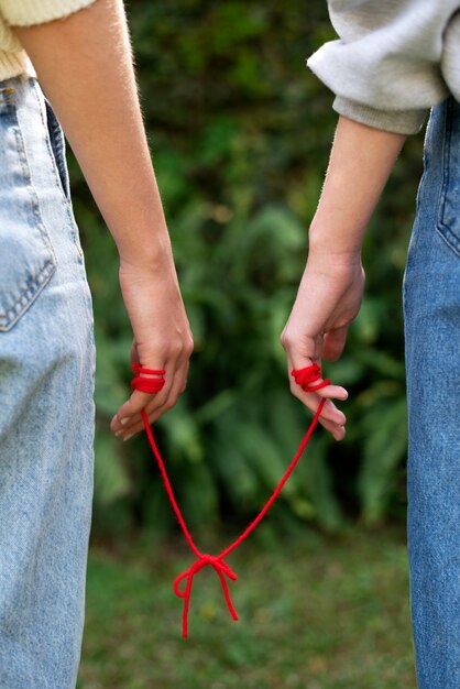 Manos humanas conectadas con hilo rojo