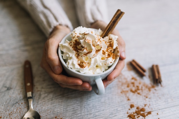 Manos humanas sosteniendo deliciosa bebida caliente