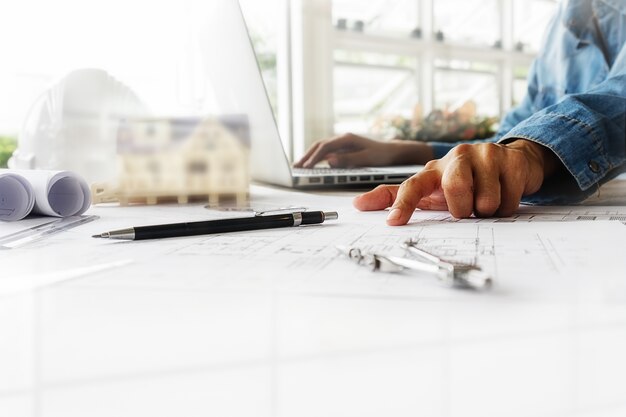 Manos del ingeniero que trabajan en blueprint, concepto de la construcción. Herramientas de ingeniería.Vintage efecto de filtro retro tono, enfoque suave (enfoque selectivo)