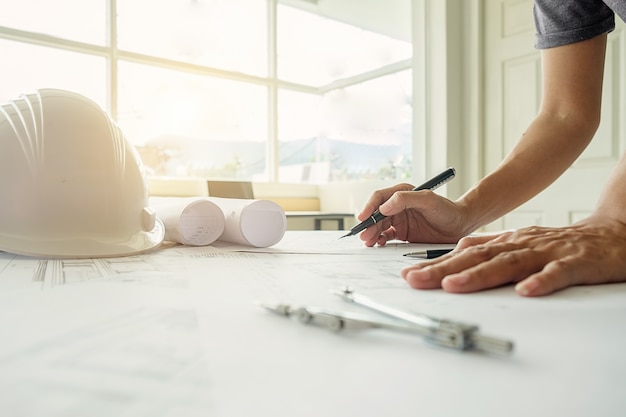 Manos del ingeniero que trabajan en blueprint, concepto de la construcción. Herramientas de ingeniería.Vintage efecto de filtro retro tono, enfoque suave (enfoque selectivo)