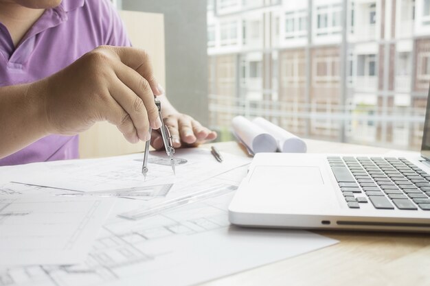 Manos del ingeniero que trabajan en blueprint, concepto de la construcción. Herramientas de ingeniería.Vintage efecto de filtro retro tono, enfoque suave (enfoque selectivo)