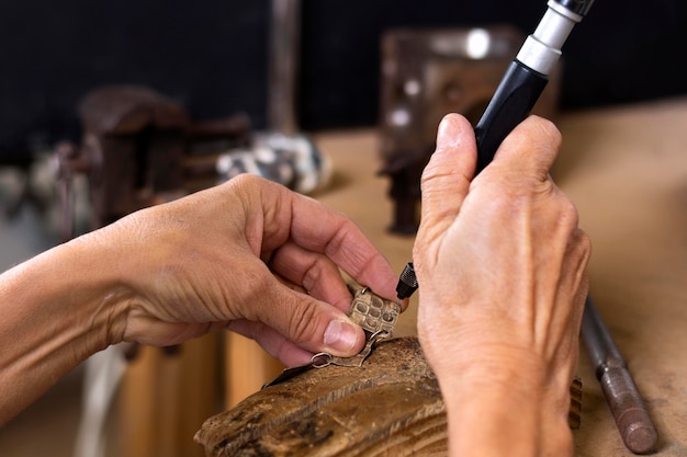 Manos de joyero creando diseño para pulsera