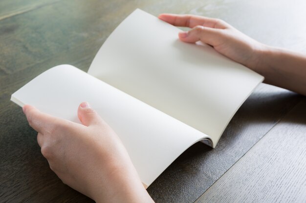 Manos con una libreta en blanco abierta