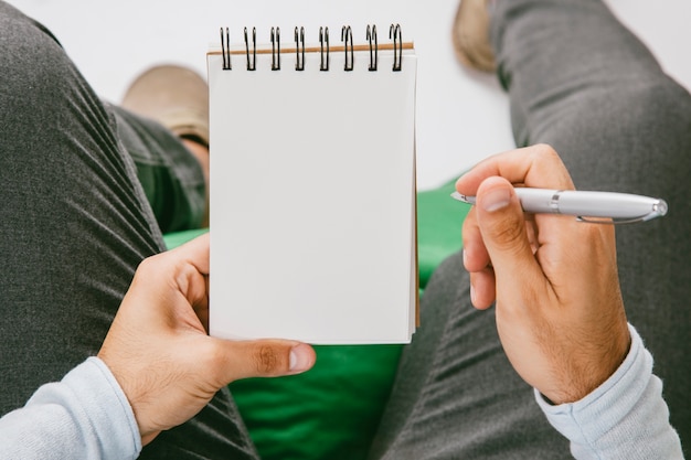 Manos masculinas con libreta y bolígrafo