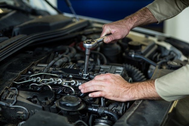 Manos de mecánico de servicios de un coche