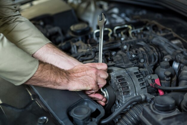 Manos de mecánico de servicios de un coche