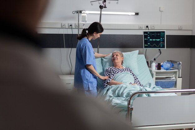 Manos del médico amigable sosteniendo la mano del paciente, en la habitación del hospital dando aliento, empatía, apoyo durante el examen médico