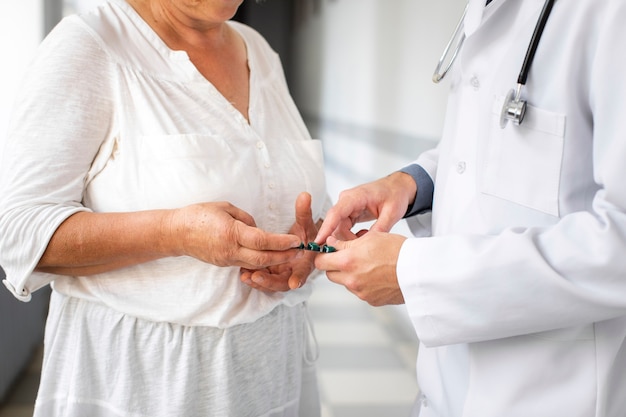 Manos del médico dando pastillas al paciente