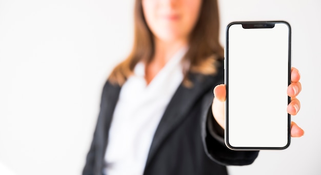 Manos mostrando un teléfono móvil con la pantalla en blanco